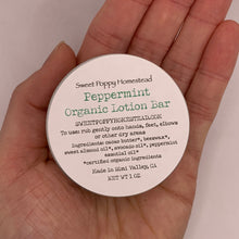 Load image into Gallery viewer, Peppermint solid lotion bar in palm of hand
